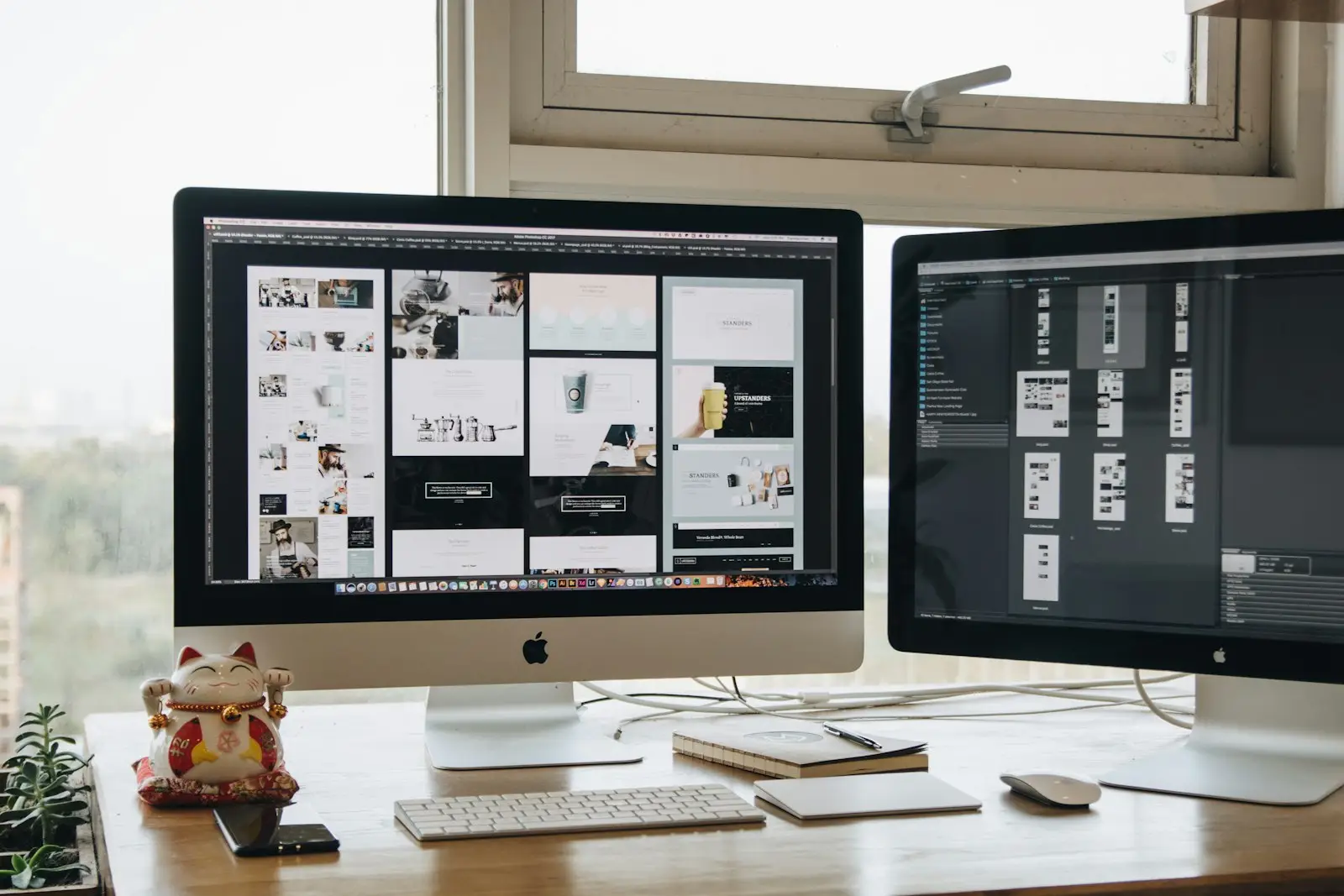 Dual monitor desk showing website design layouts